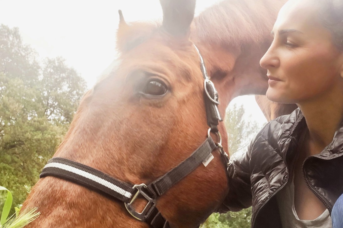 Géraldine close to her chestnut horse